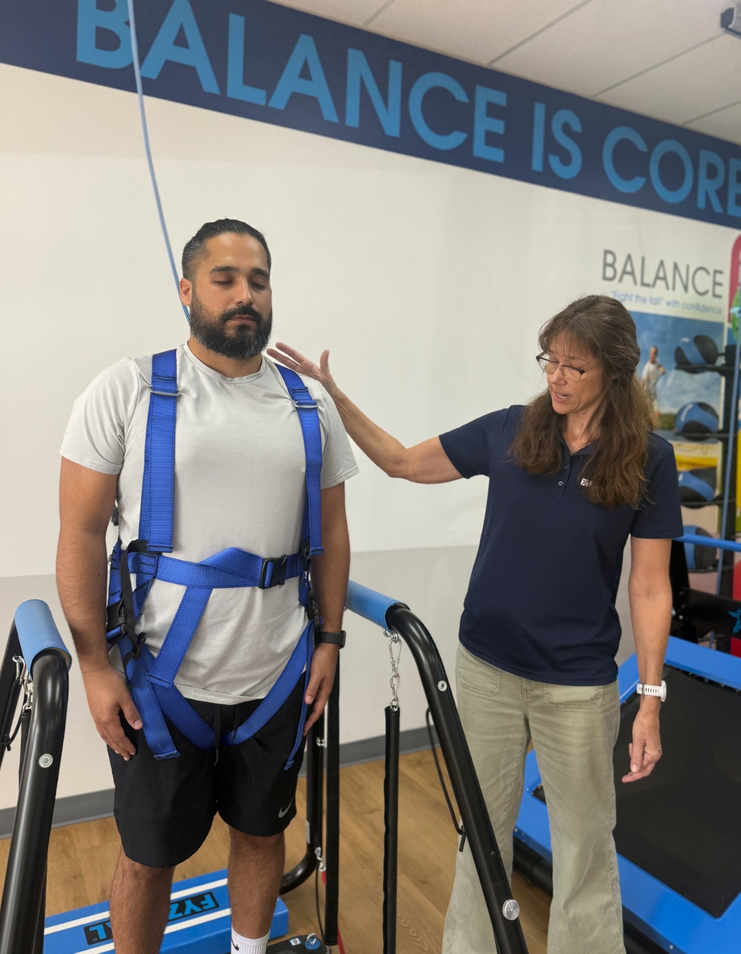 Patient secured in the Safety Overhead System harness performing a balance exercise confidently